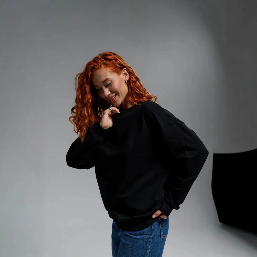 Black crew neck sweatshirt with long sleeves and relaxed fit, ribbed cuffs