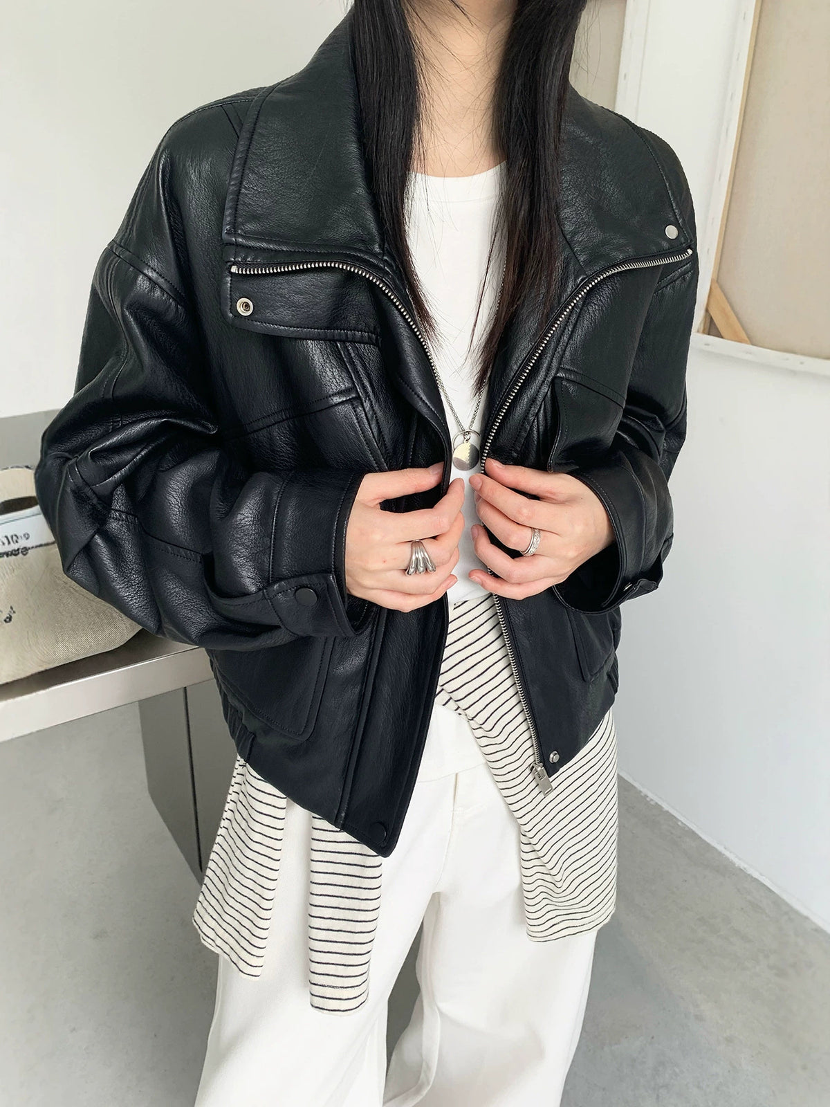 Black PU leather jacket with stand collar, snap-flap pockets, diagonal zip