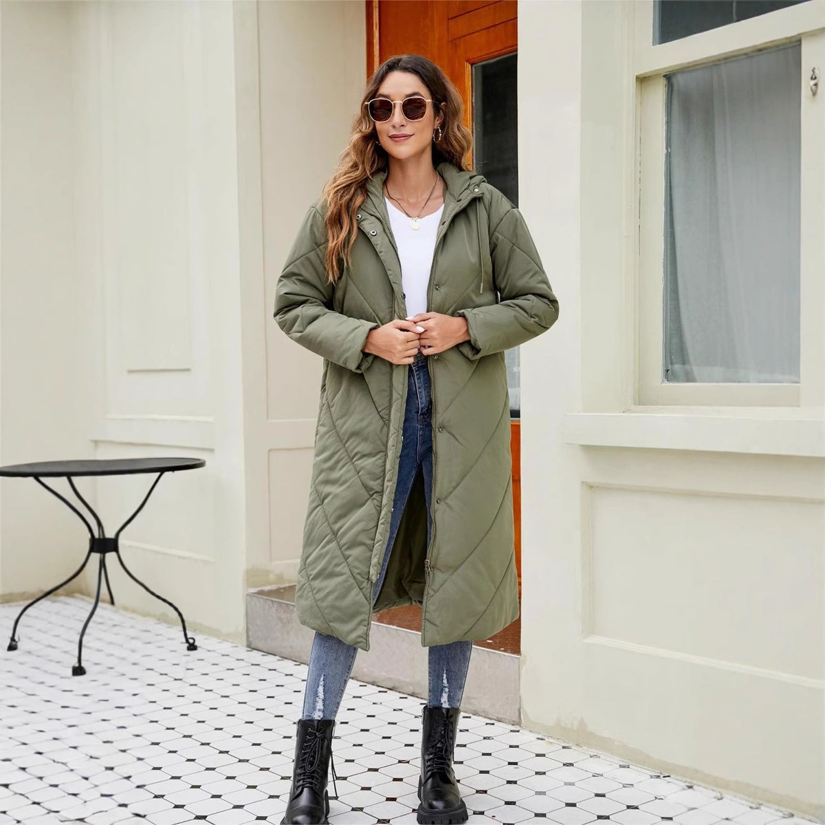 Women's long padded coat in military green, hooded zip closure, roomy silhouette.