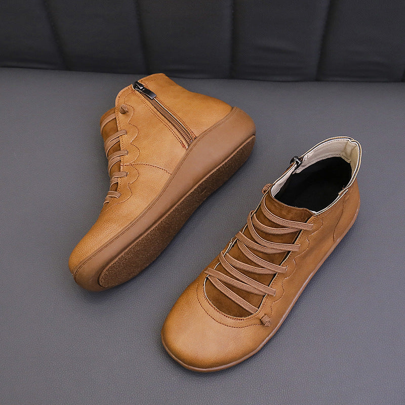Light brown women's ankle boots with flat soles, lace-up fronts and side zippers.