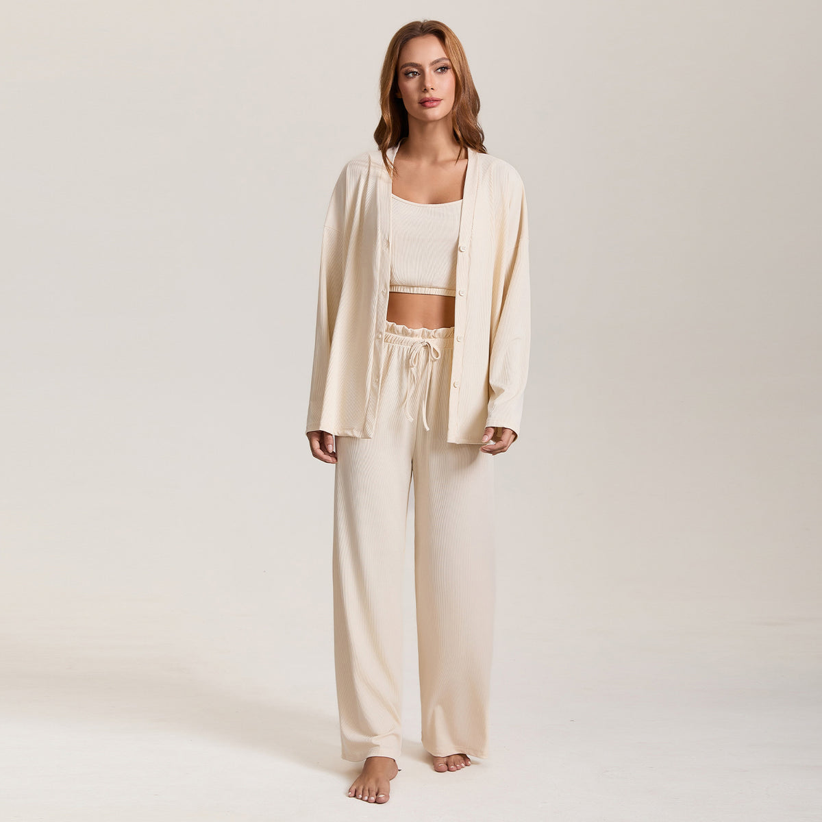 Women’s cream pajama three-piece set with cropped top, long-sleeve jacket, and wide-leg pants