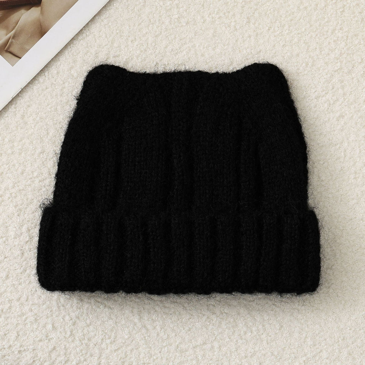Black cat-ear knit beanie, folded flat, fuzzy thick knit with ribbed band