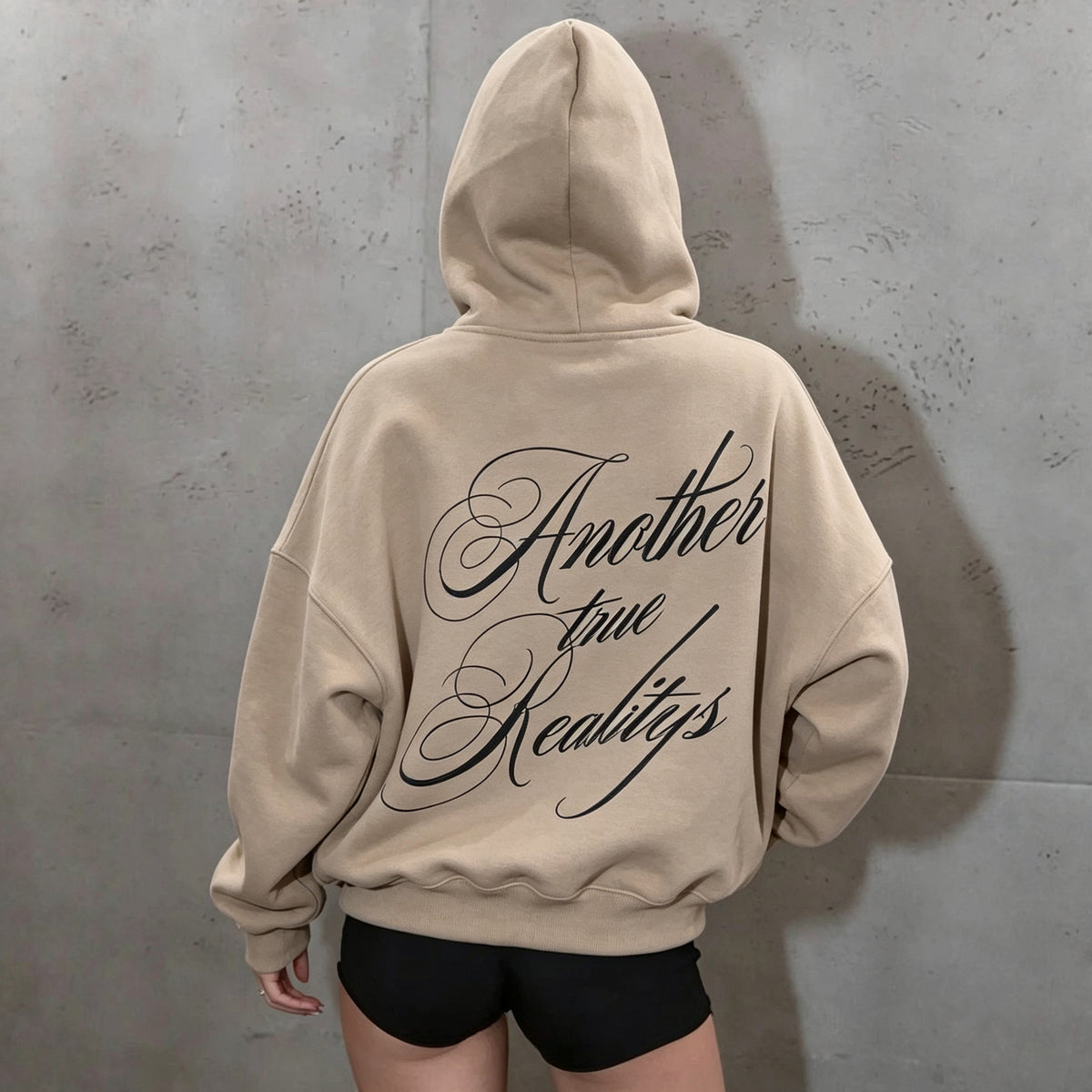 Beige women's hoodie with a hood and large black script lettering across the back