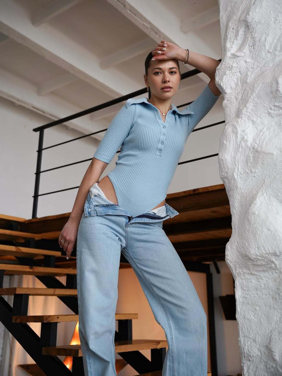 Sky blue ribbed knit bodysuit with polo collar and button placket, short sleeves