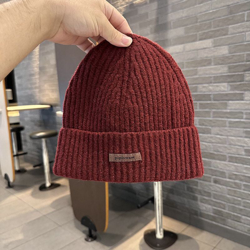 Burgundy ribbed knit beanie hat with folded brim and pipiswoot logo patch