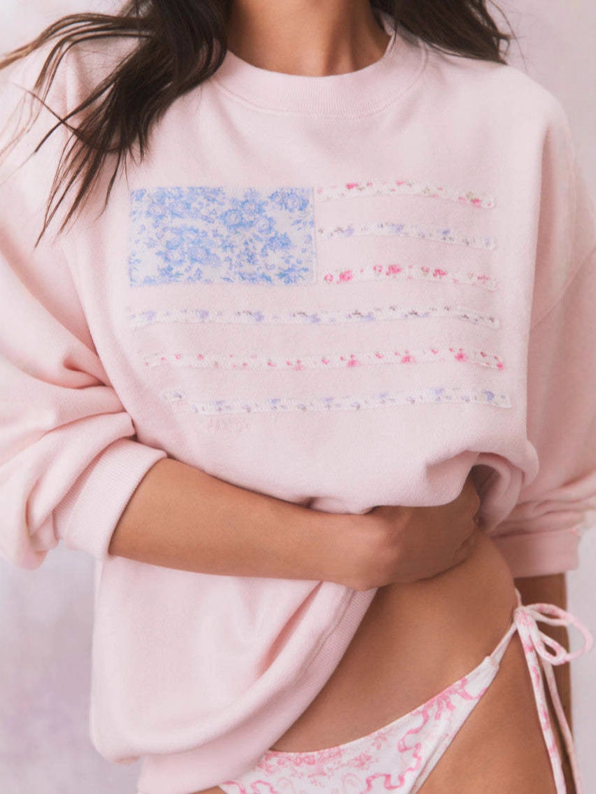 Pink crewneck velvet sweatshirt with blue and red flag stripe graphic print, long sleeve