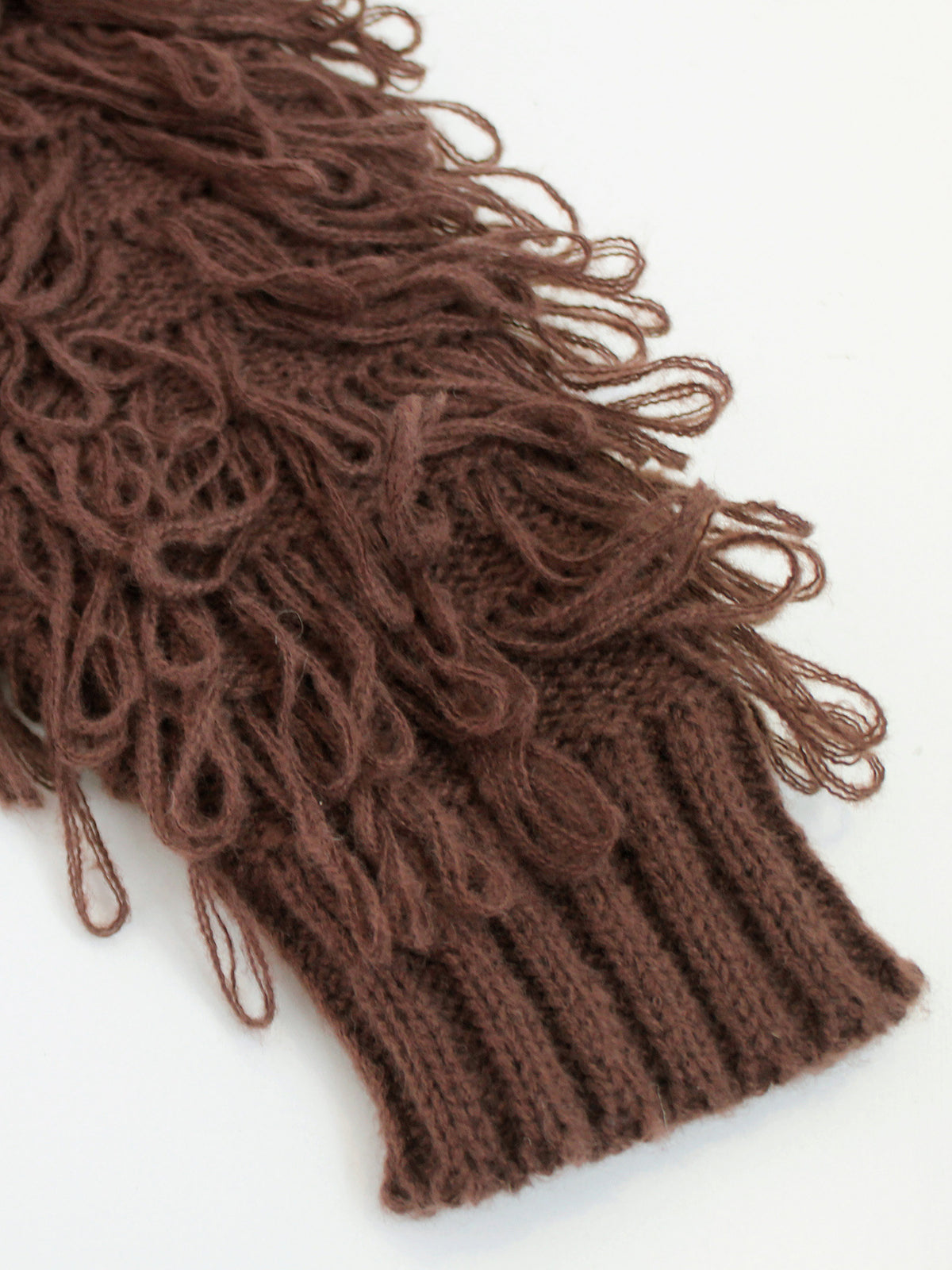 Brown knitted jacket hem with dense fringe texture