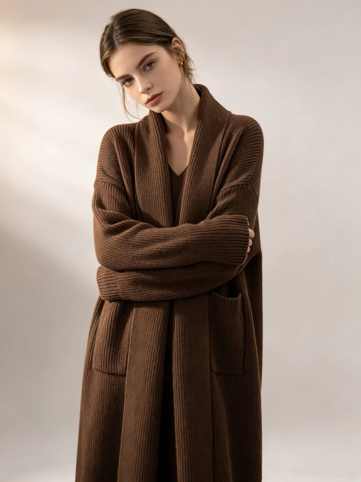 Brown knitted cardigan sweater with open front, long sleeves, and patch pockets