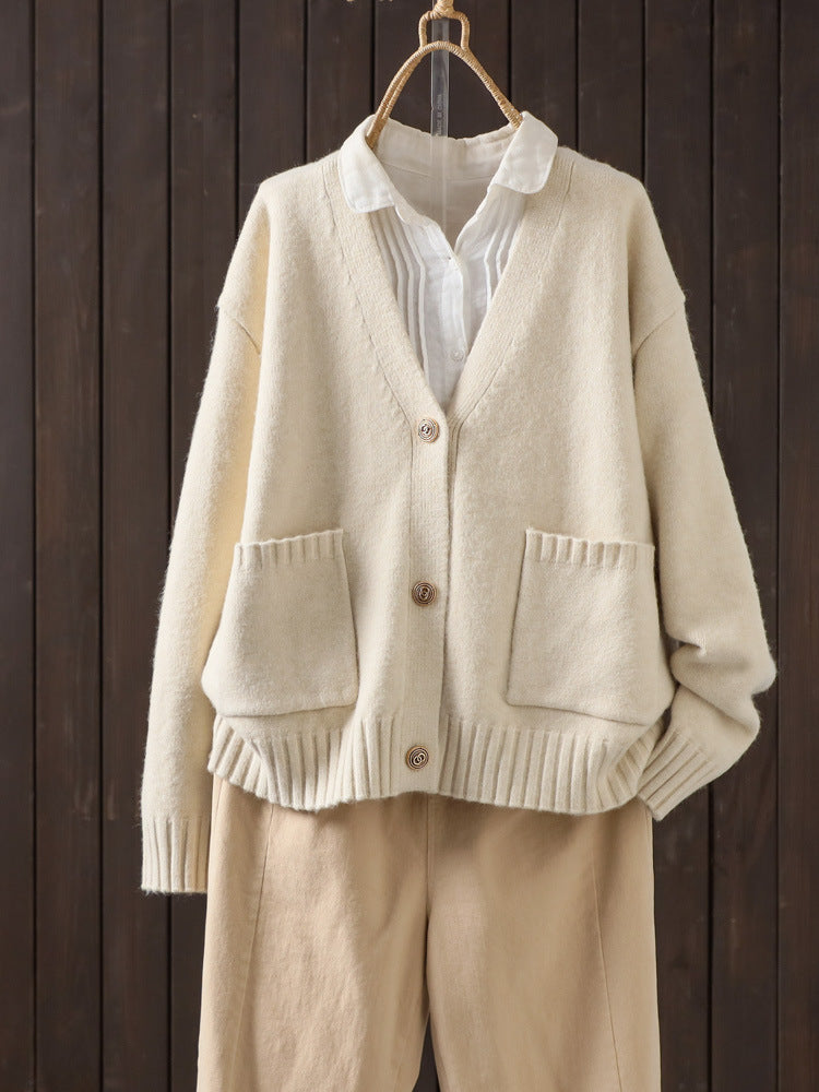 Off-white wool cardigan on hanger with V-neck button front and patch pockets