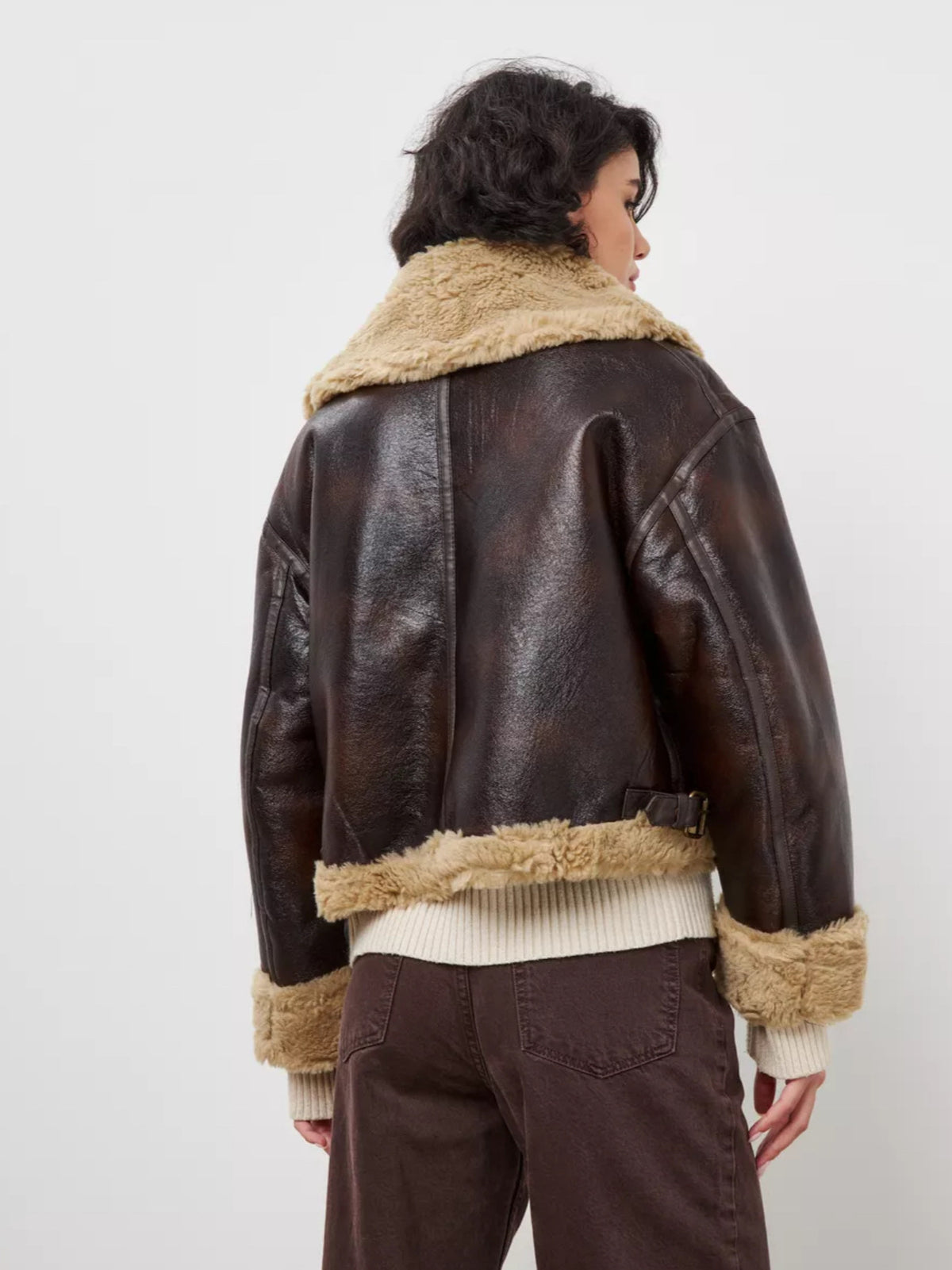Women's brown leather jacket with tan shearling back panel, zip front, ribbed hem