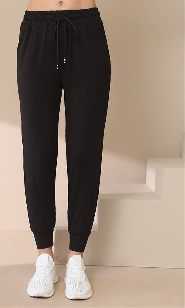 Black jogger pants with drawstring waist and tapered cuffs, side pockets
