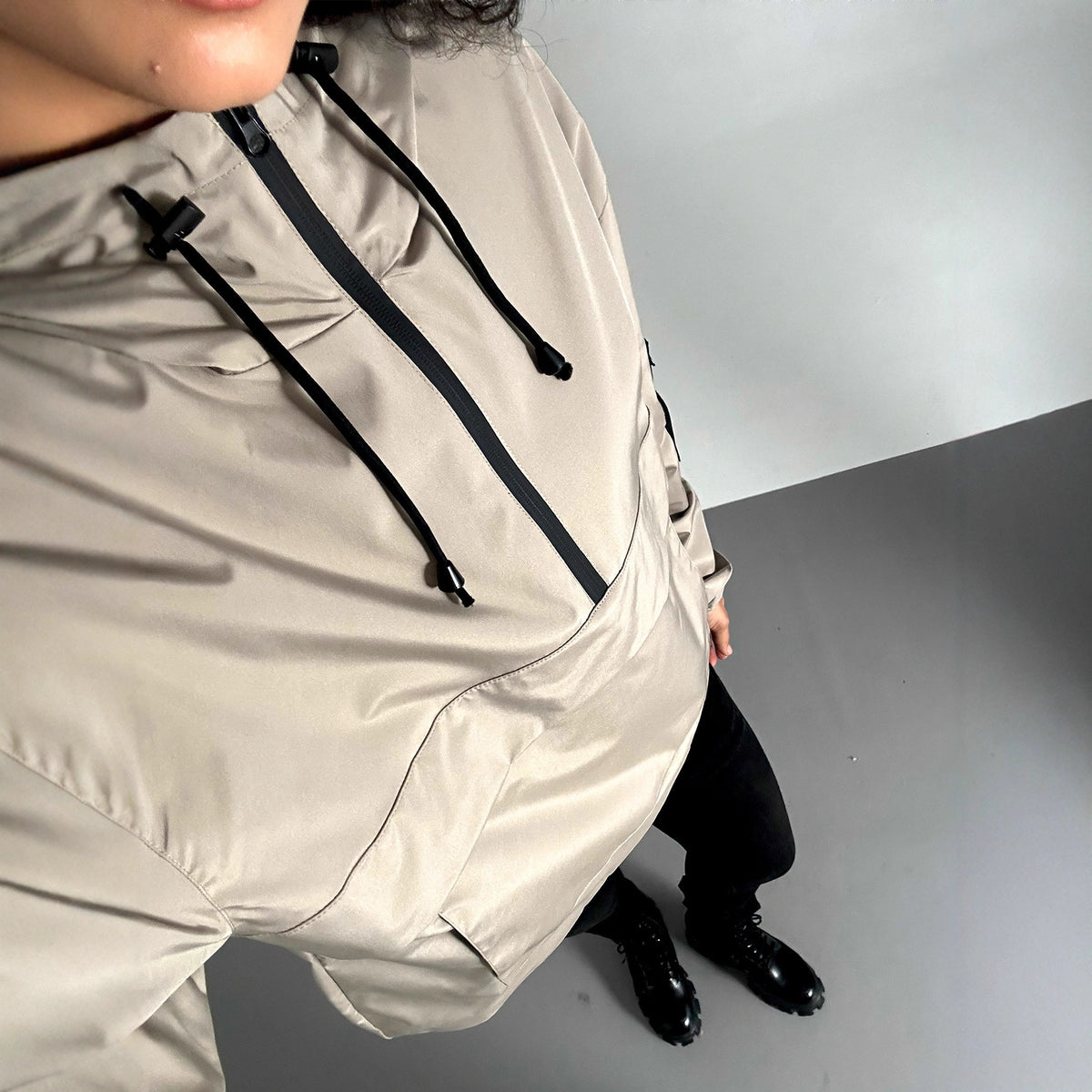 Women’s light gray hooded windproof jacket with black drawstrings and center front zipper