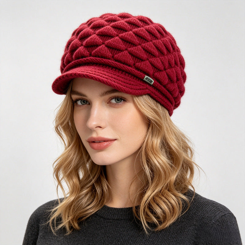 Red fleece-lined knit beanie with quilted texture and stitched logo patch