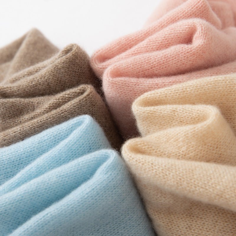 Cashmere scarf knit close-up in beige, light blue, pink, and tan with soft texture