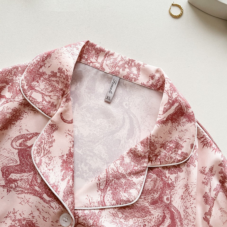 Pink button-up pajama shirt with contrast piping and jungle print, close-up