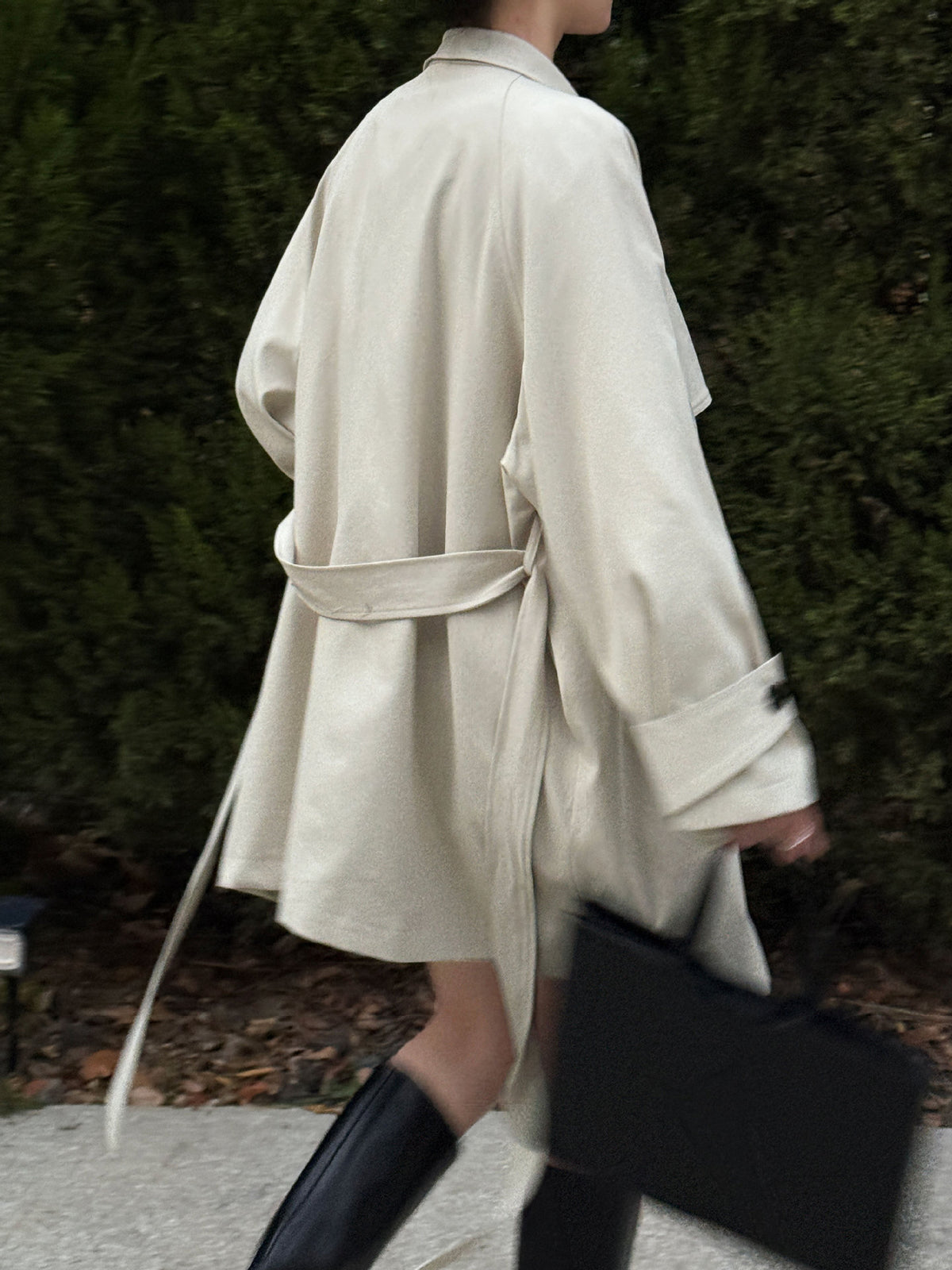 Women’s light cream wrap coat with draped front and tie belt at waist, button cuffs