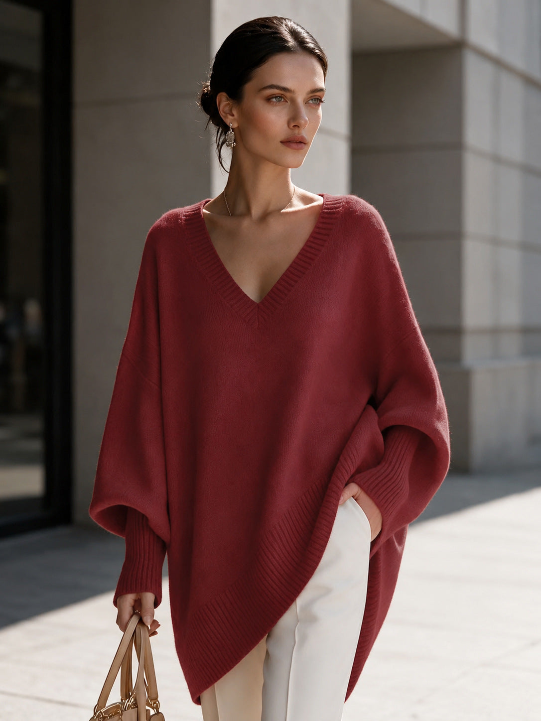 Women's red V-neck knit pullover with batwing sleeves and asymmetric hem