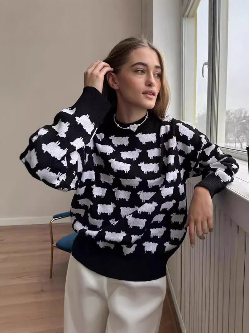 Women’s crewneck knit sweater, black with white sheep pattern, long sleeves worn