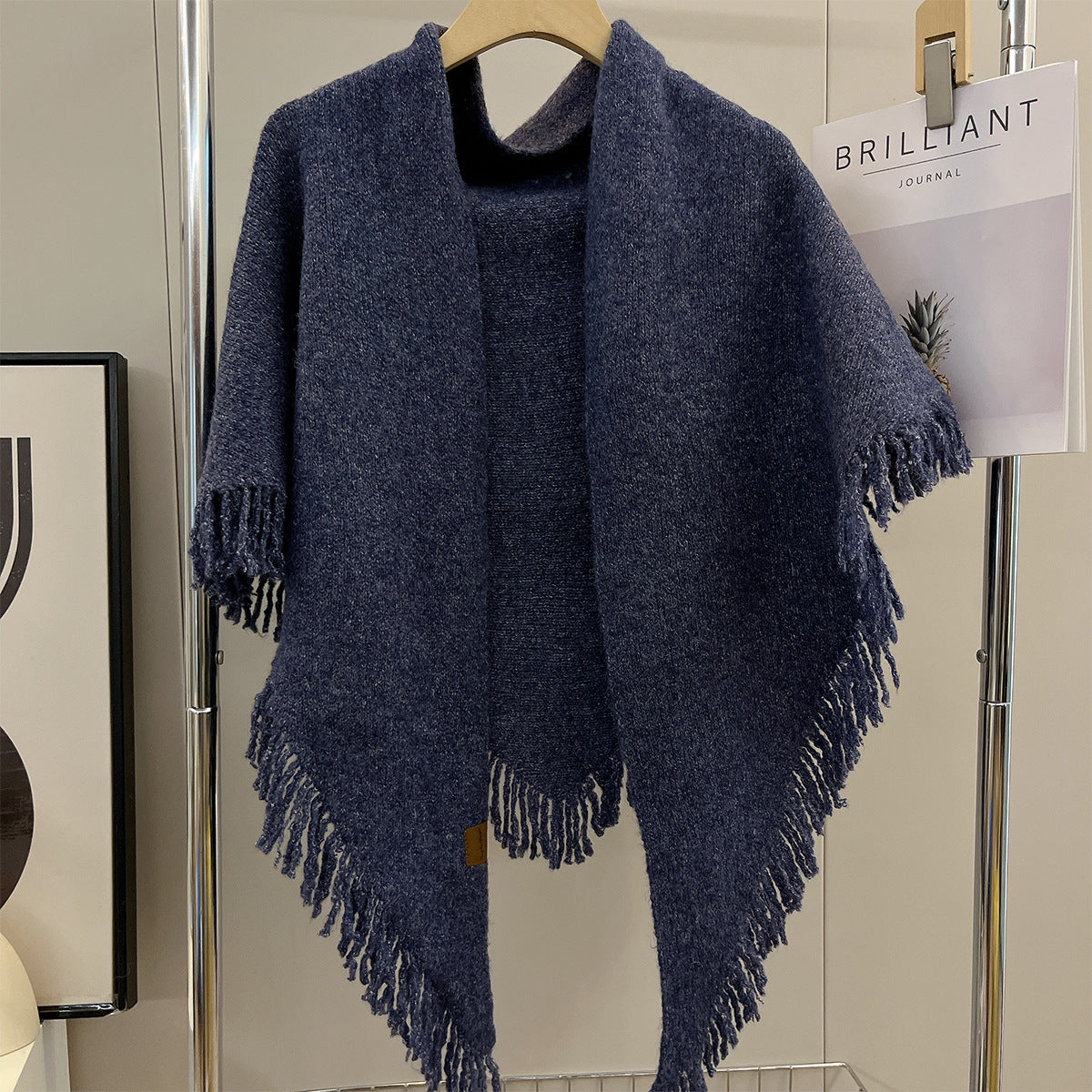 Navy blue large triangle shawl with tassel fringe trim, draped on hanger