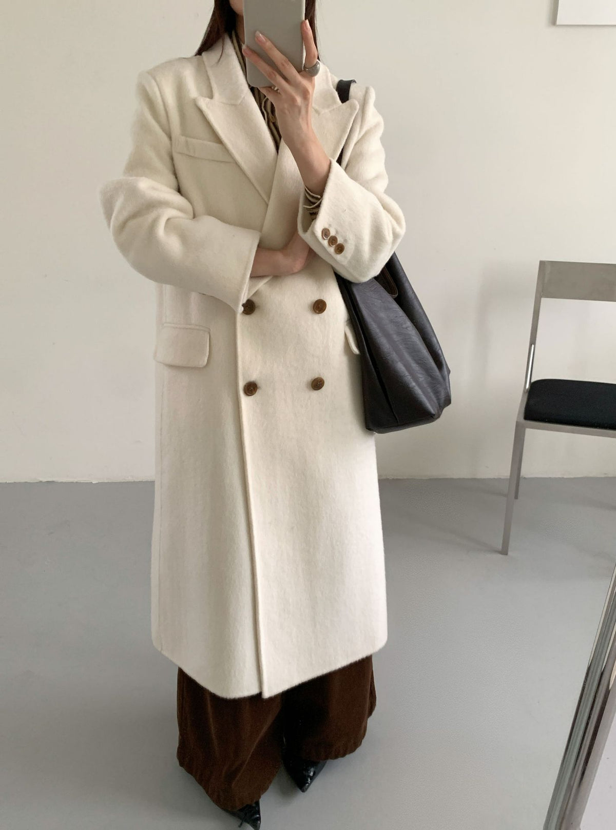 Off-white long double-breasted cashmere coat with notched lapel, flap pockets, and buttons