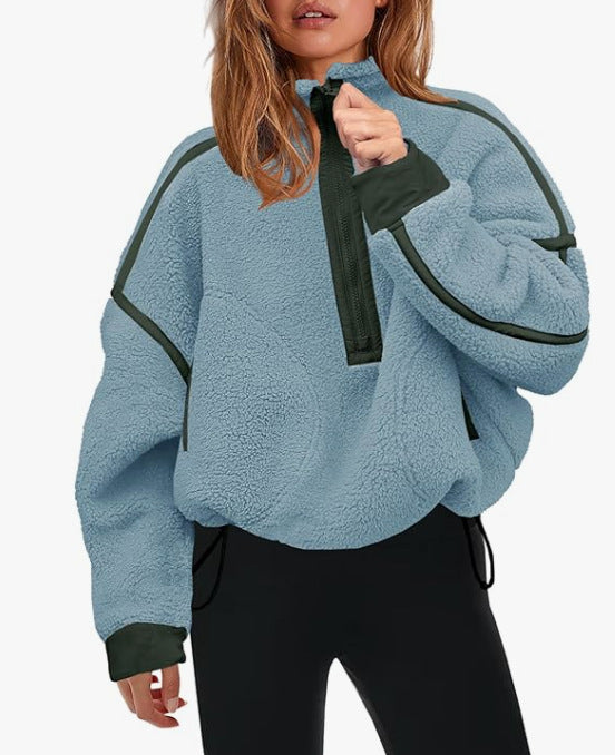 Plush quarter-zip sweatshirt in light blue with dark green trim and pull tab