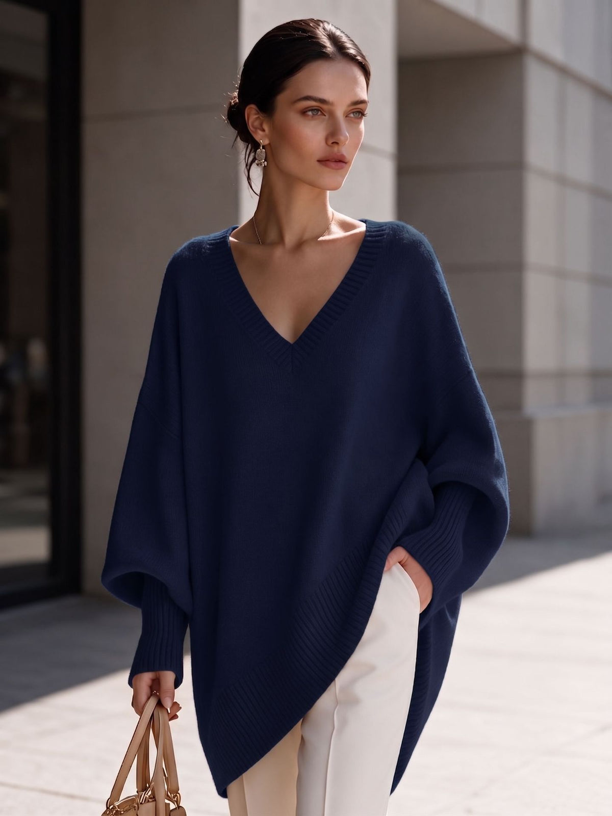 Women's navy V-neck knit pullover with batwing sleeves and asymmetric hem