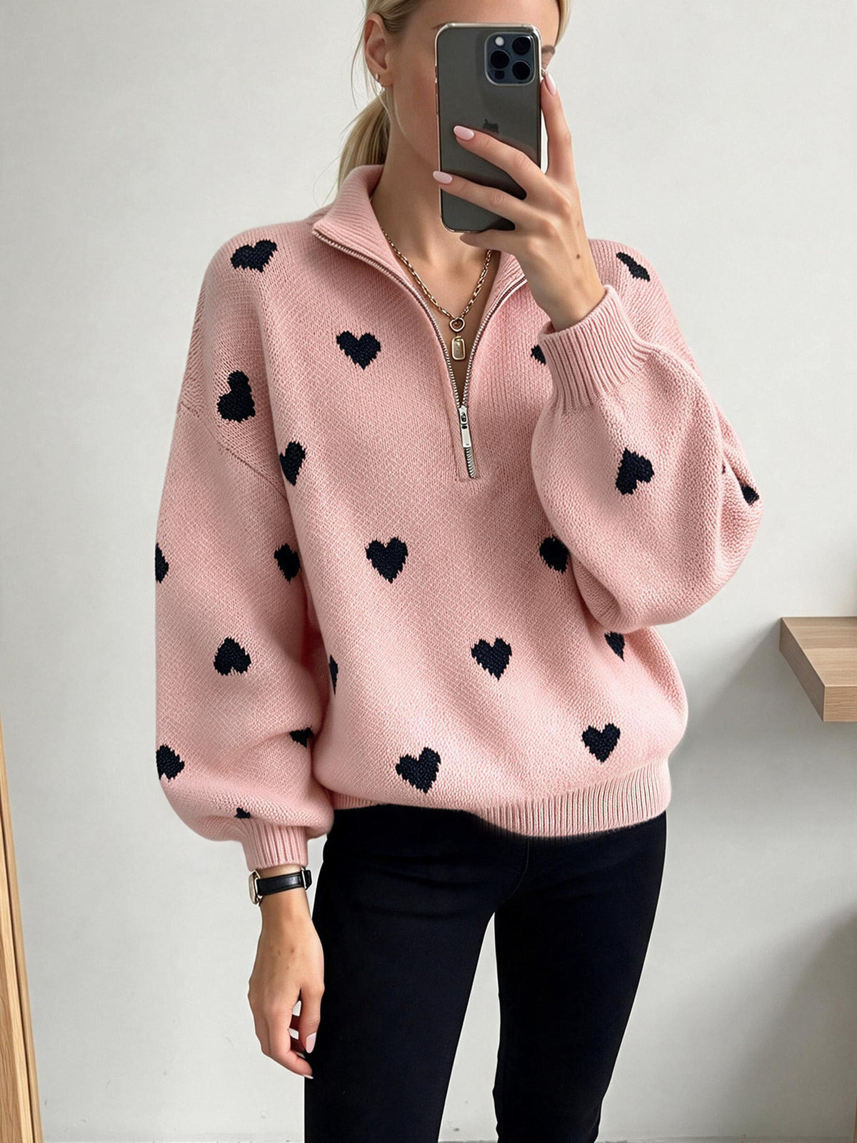 Pink heart-pattern knit sweater with a quarter zip, high neck and ribbed hem.