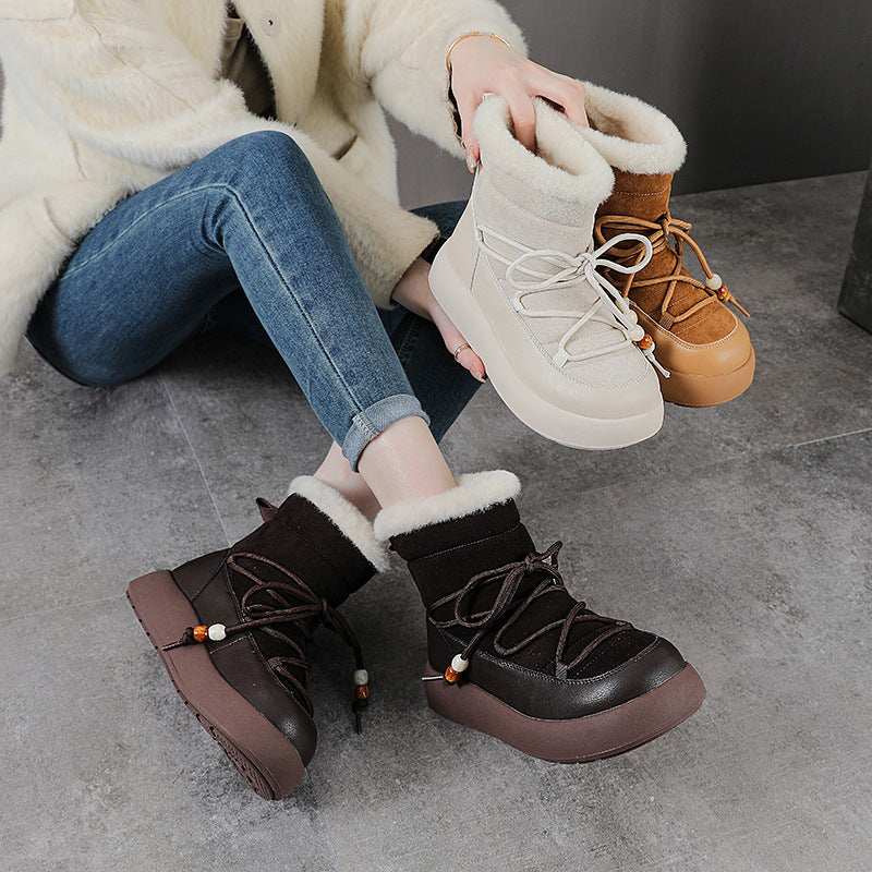 Pair of winter snow boots in brown and black with fuzzy cuffs and lace-up fronts