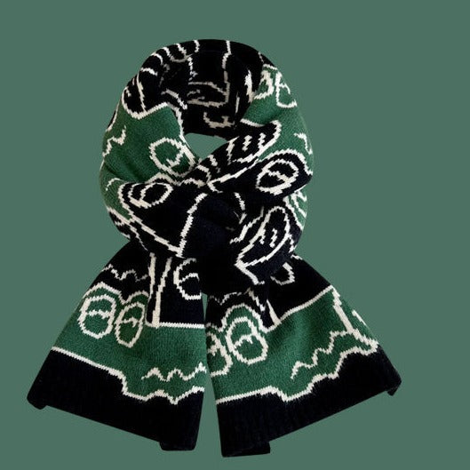 Dark knitted scarf with green and white patterned graphic, ribbed ends