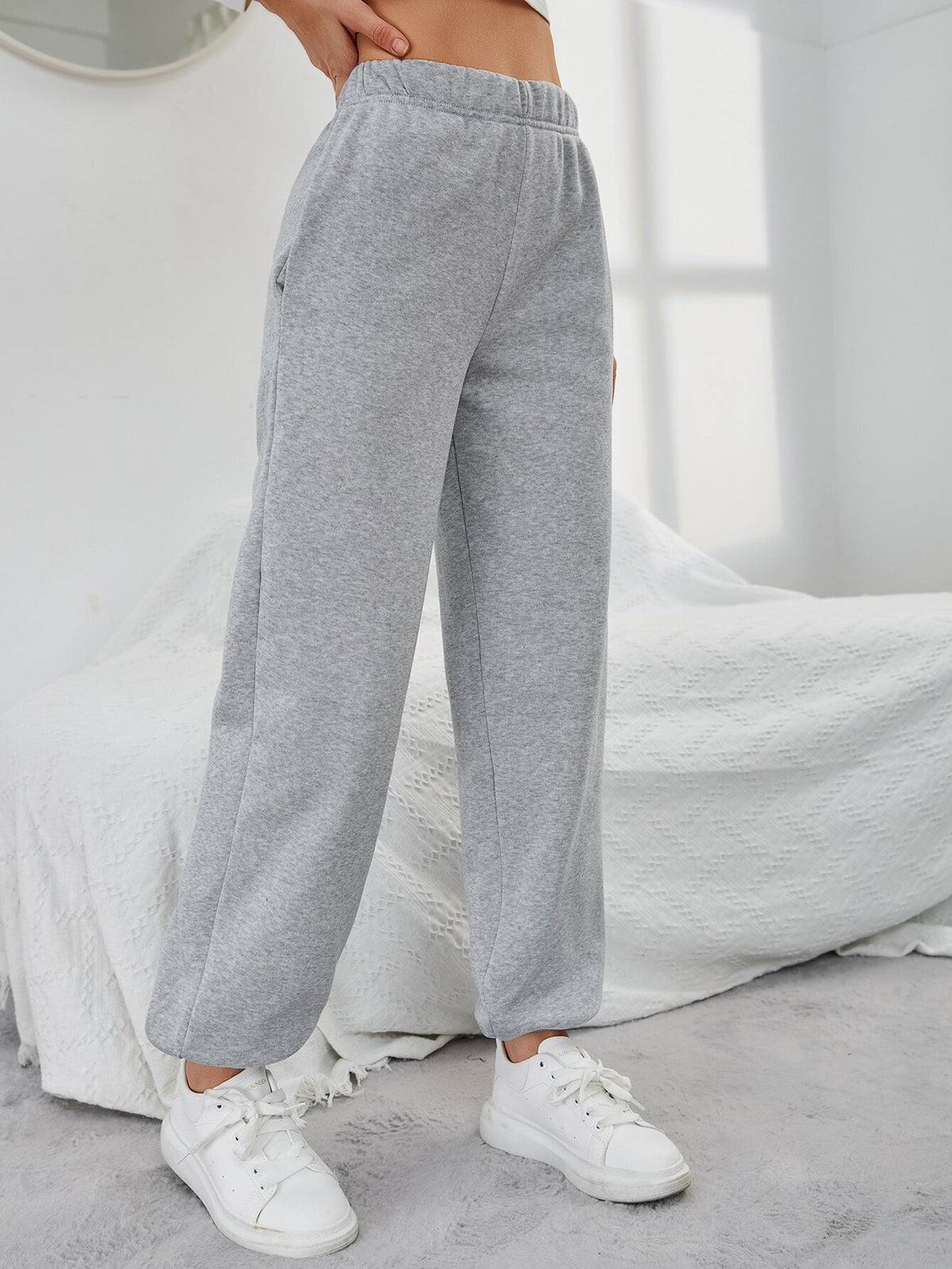Grey high-waisted straight-leg sweatpants from back view with side pockets