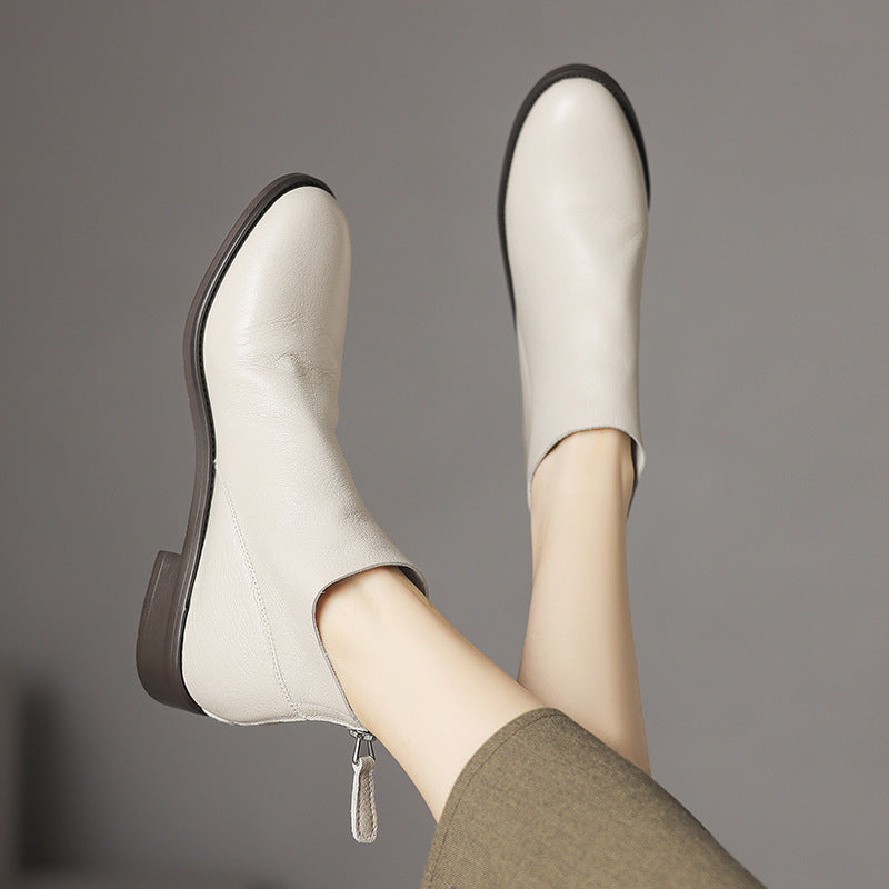 Women’s off-white short ankle boots with side zipper and tapered toe.