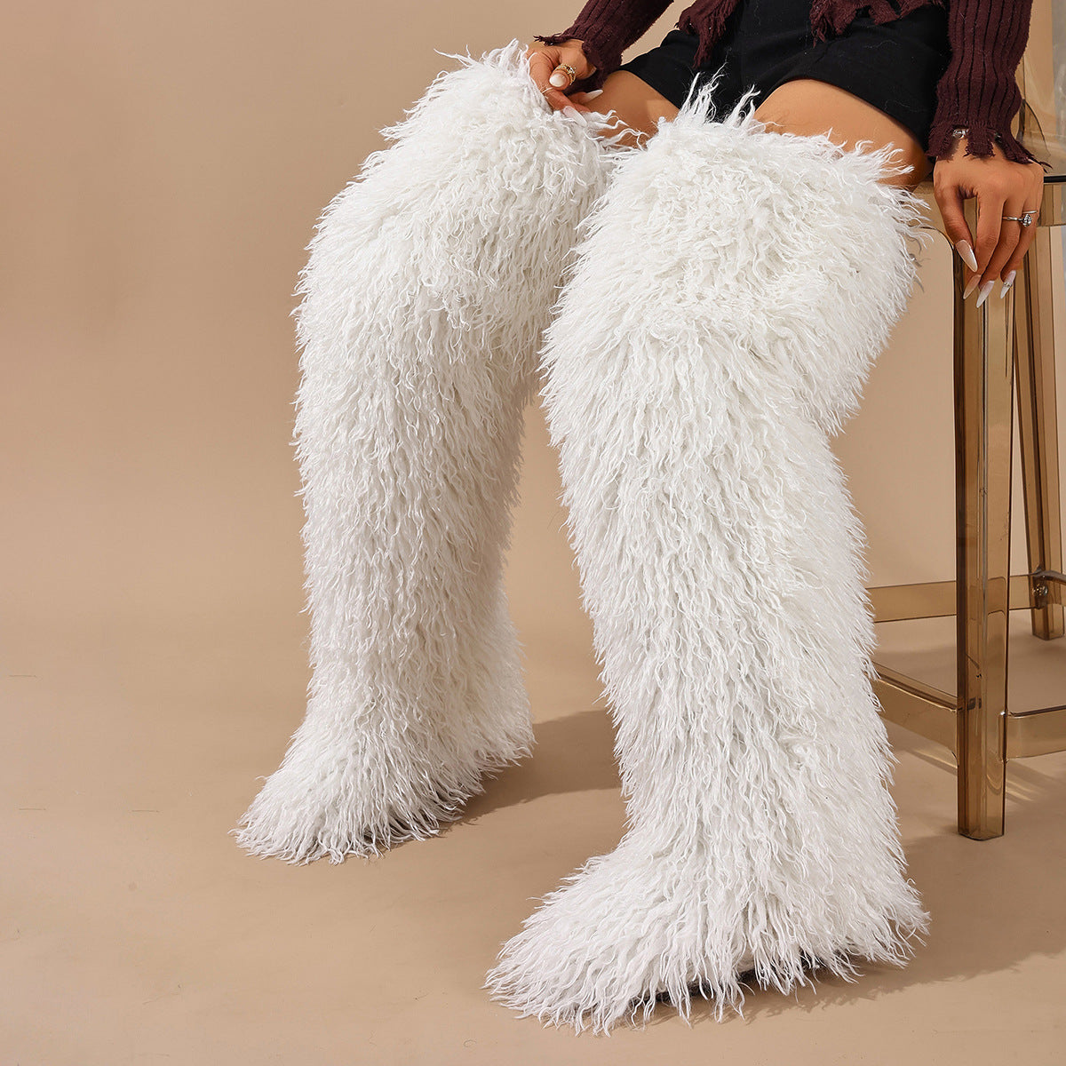 White faux-fur thigh-high boots with long pile, shown worn on both legs.
