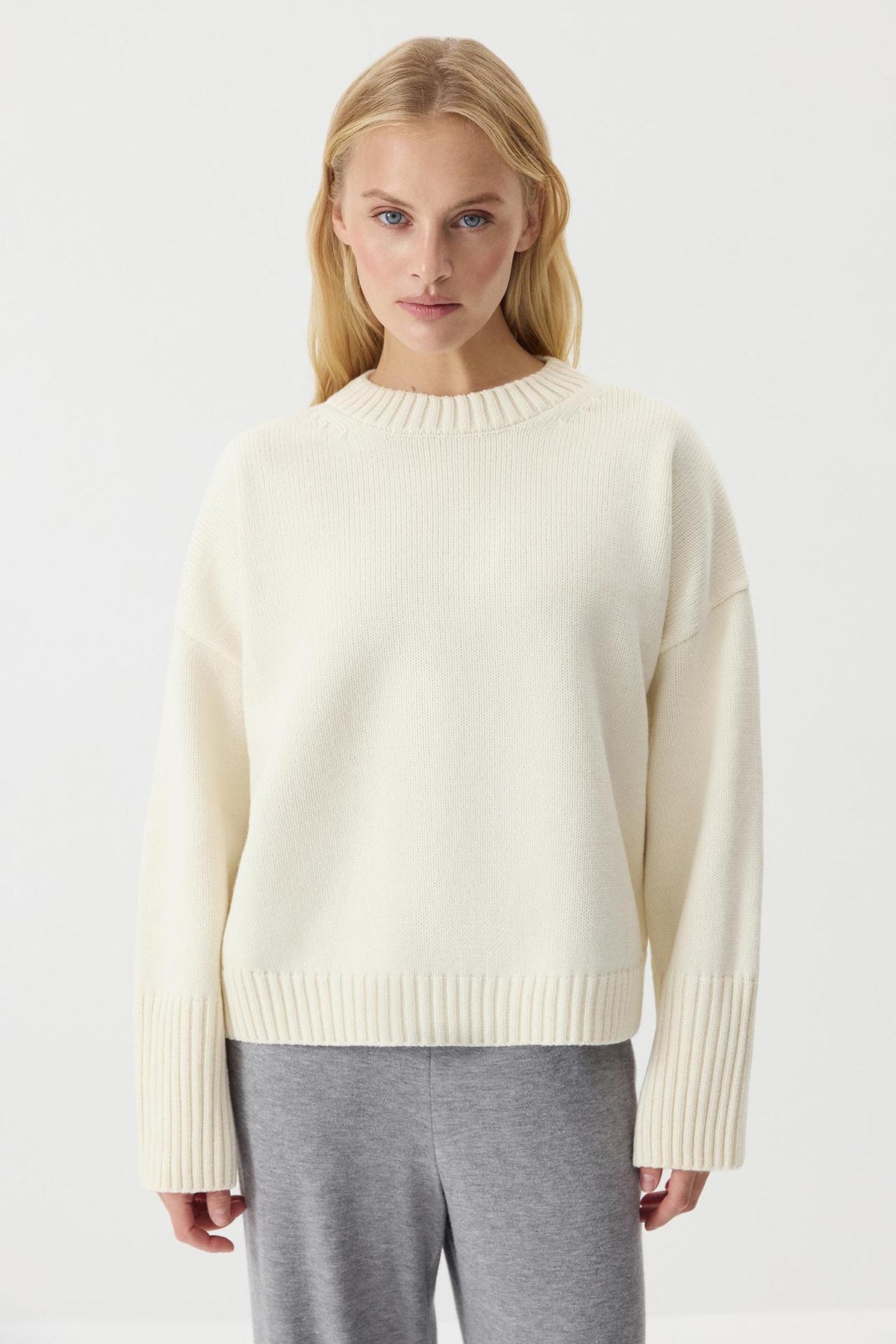 Women's off-white knit sweater with crew neck, long sleeves, ribbed hem