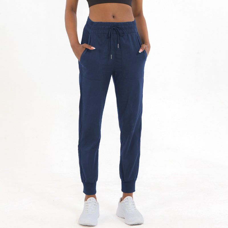 Navy jogger pants with drawstring waist, side pockets, and tapered ankle cuffs