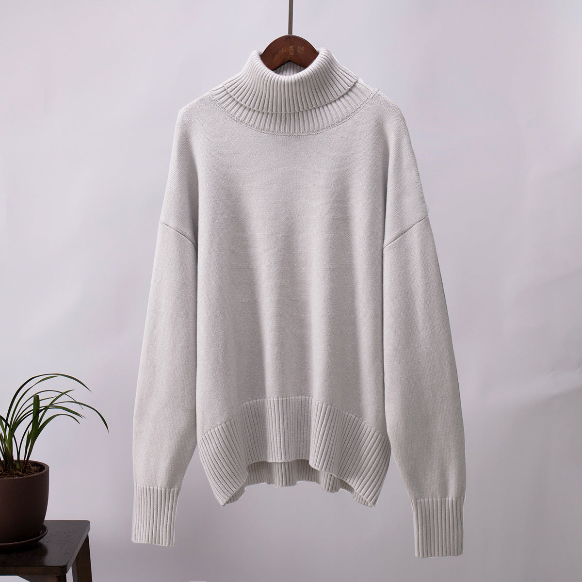White knit turtleneck pullover sweater with loose fit, ribbed cuffs, and hem