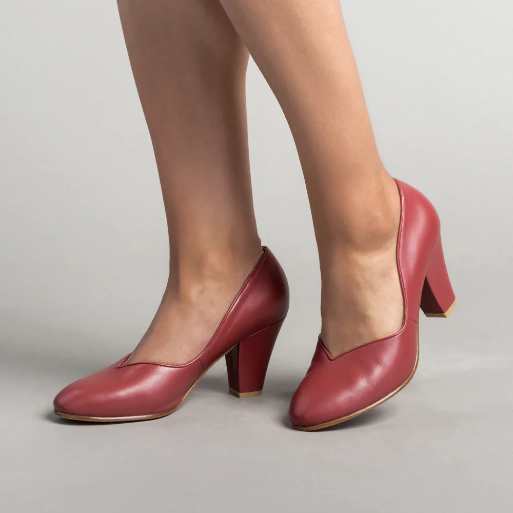 Red pumps with rounded toes and thick block heels, shown at an angled view