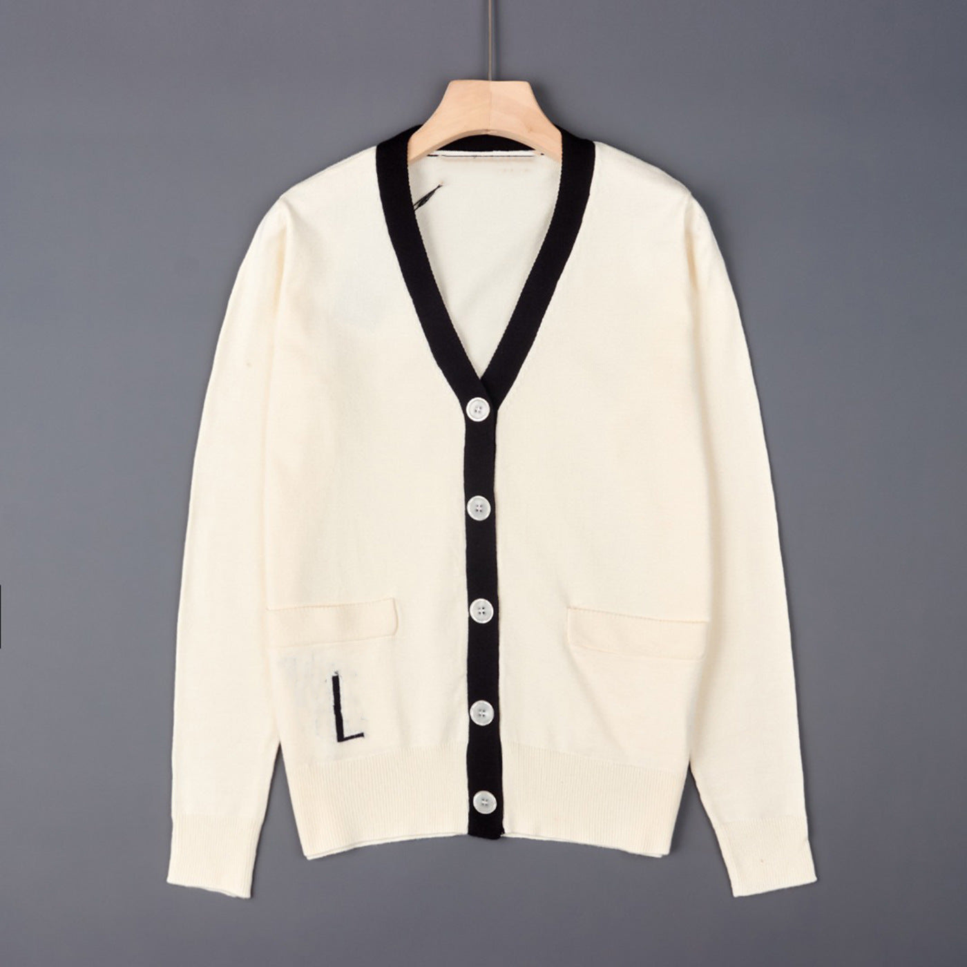 Off-white V-neck knit cardigan with black trim, button front, and chest pockets
