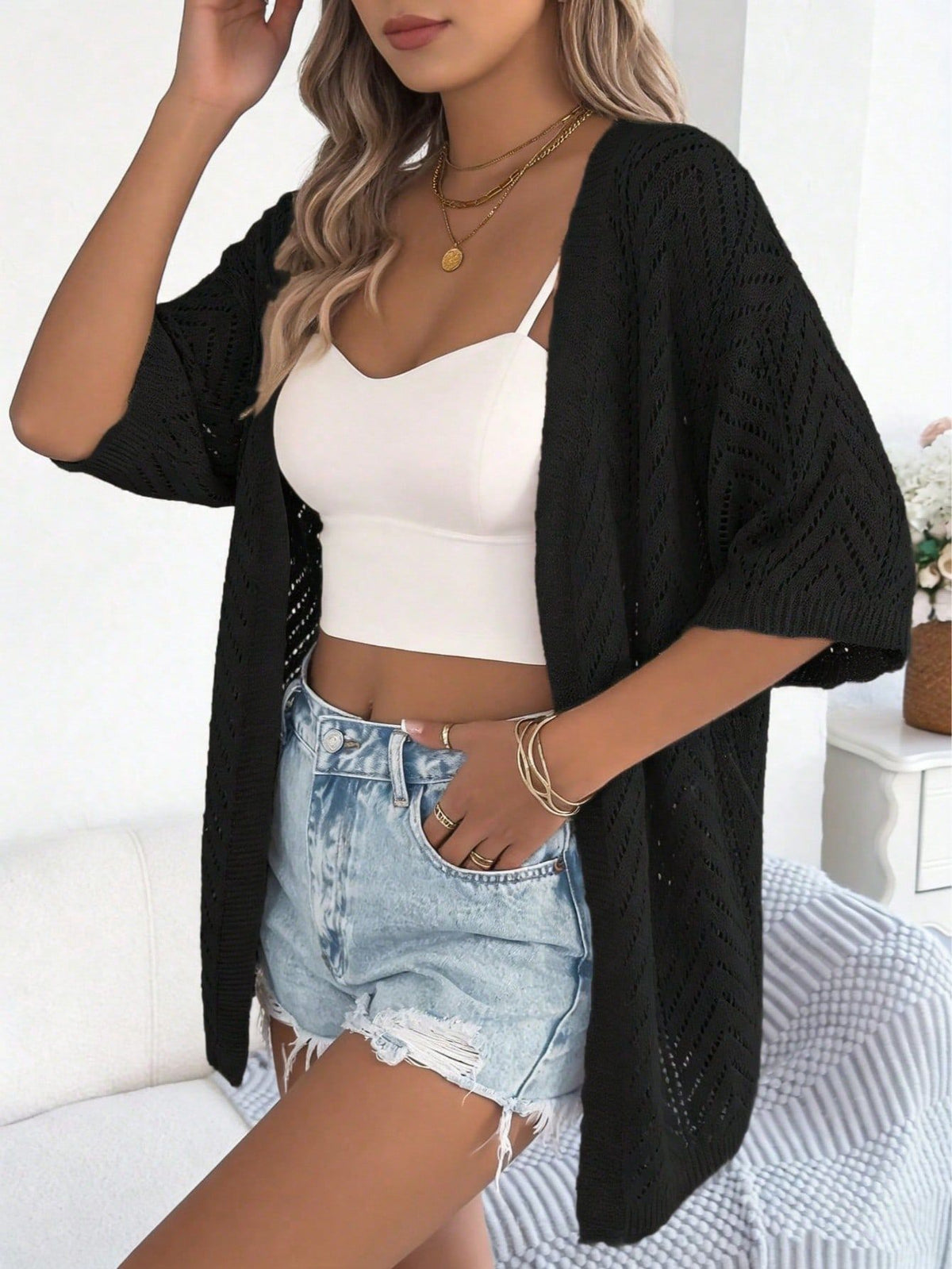 Women’s open-knit short-sleeve cardigan in black, textured chevron-knit draped front.