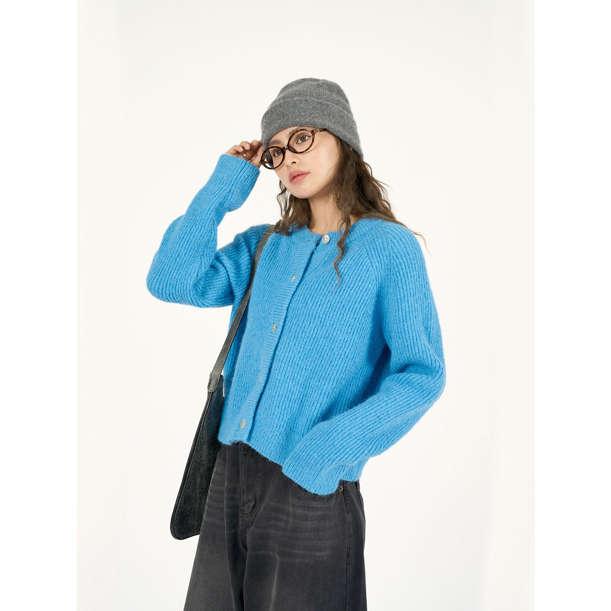 Blue round-neck cardigan worn with dark jeans