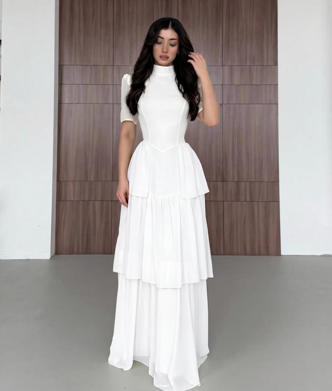 White chiffon tiered maxi dress with high neck and short puff sleeves.