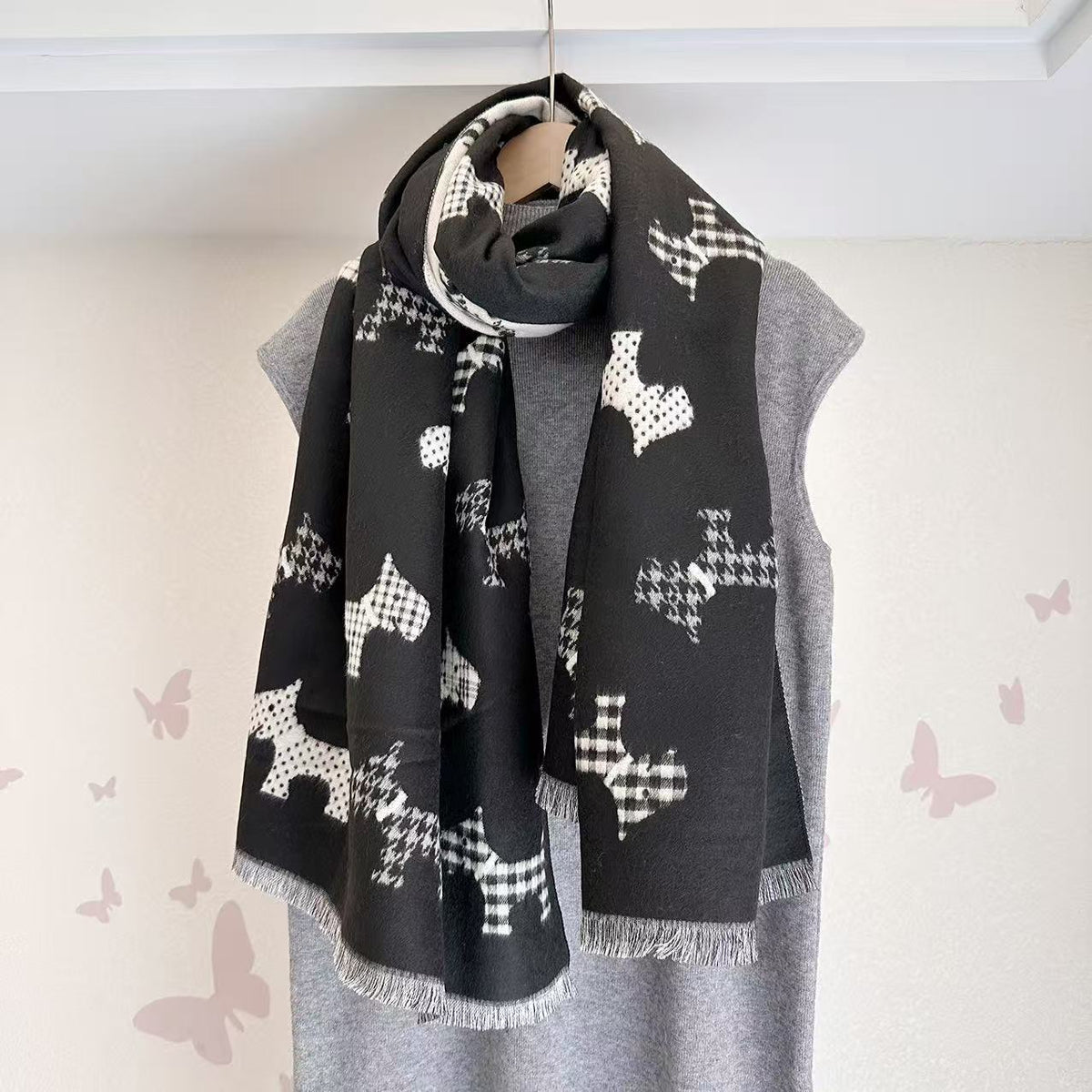 Black scarf with dog motifs and fringed ends, draped around the neck
