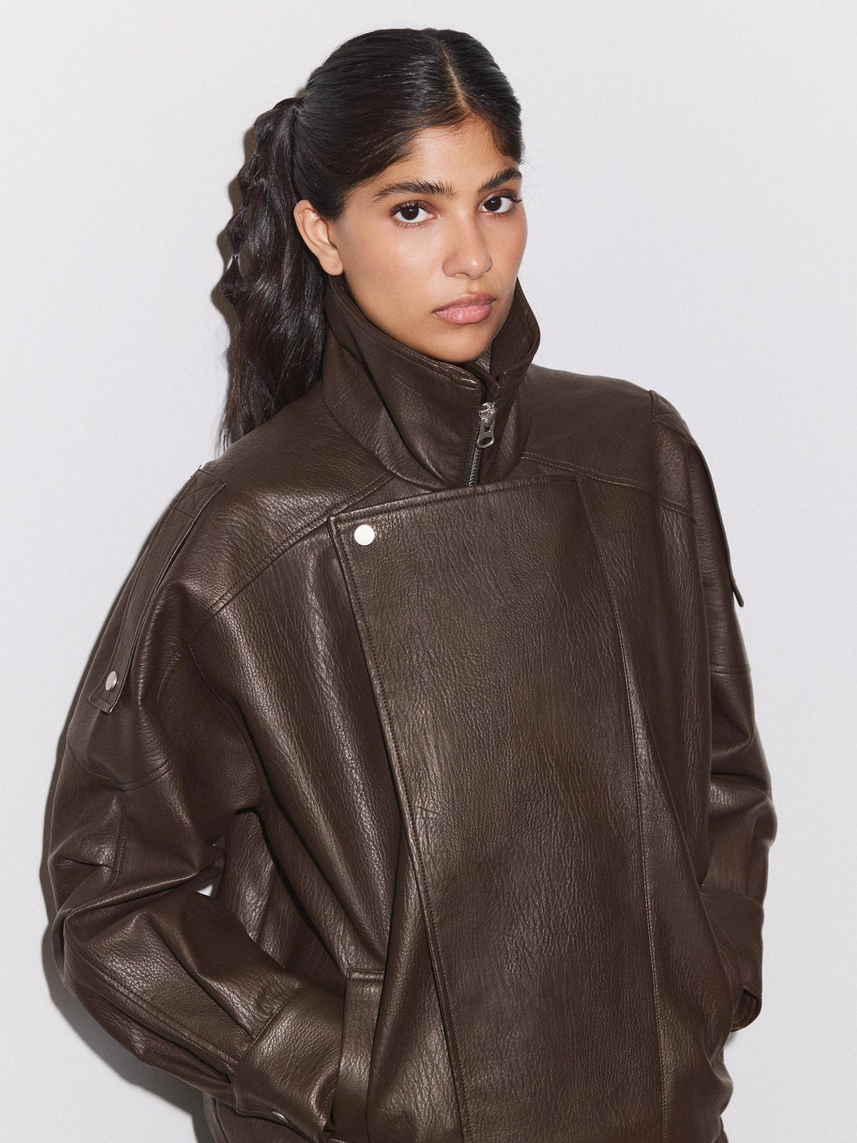Brown leather biker jacket with stand collar, front zip, oversized patchwork panels, long sleeves