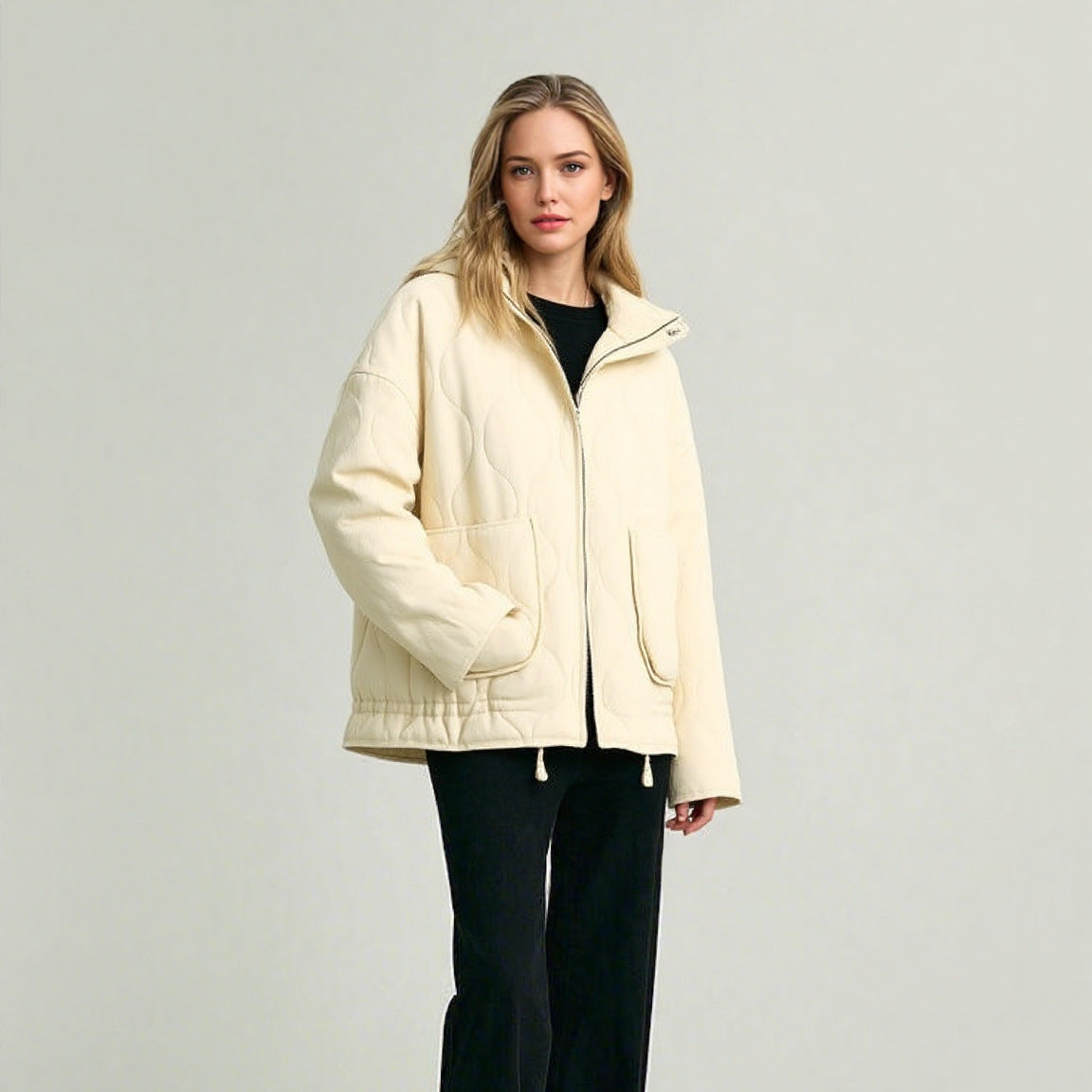 Cream quilted stand-up collar zip-front jacket with two flap pockets and drawstring hem.