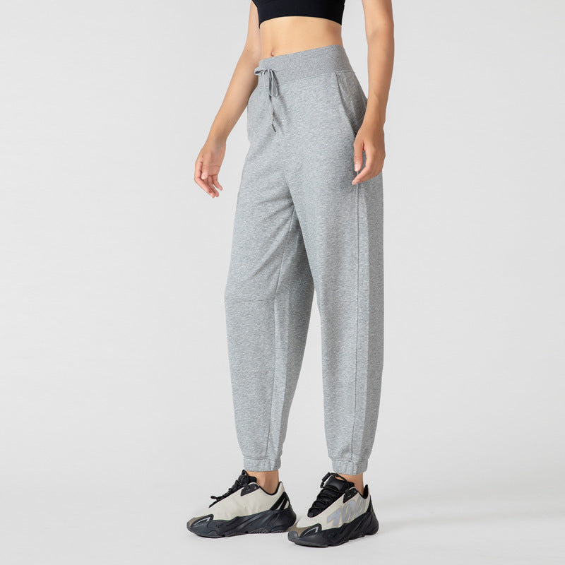 Women's light gray jogger sweatpants with a drawstring waist and elastic ankle cuffs