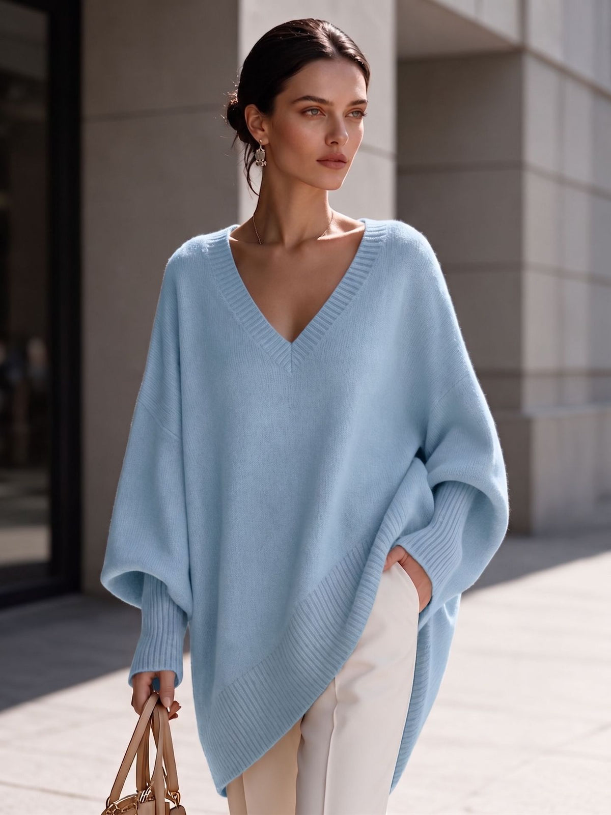 Women's light blue V-neck knit pullover with batwing sleeves and asymmetric hem