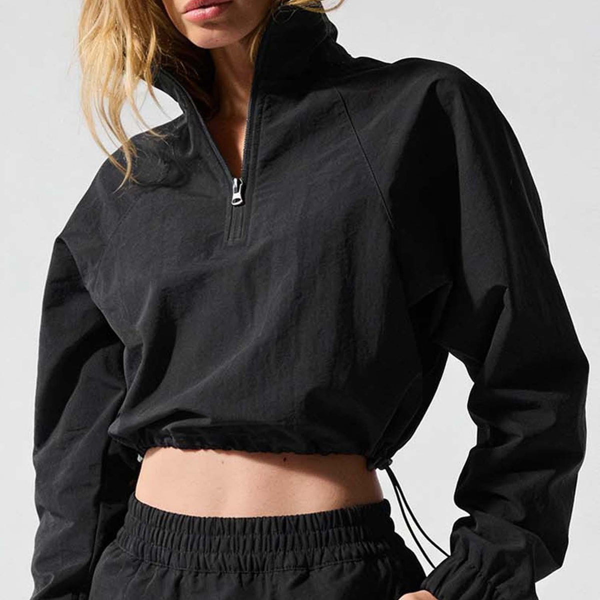 Black cropped quarter-zip wind jacket with drawstring hem and elastic cuffs