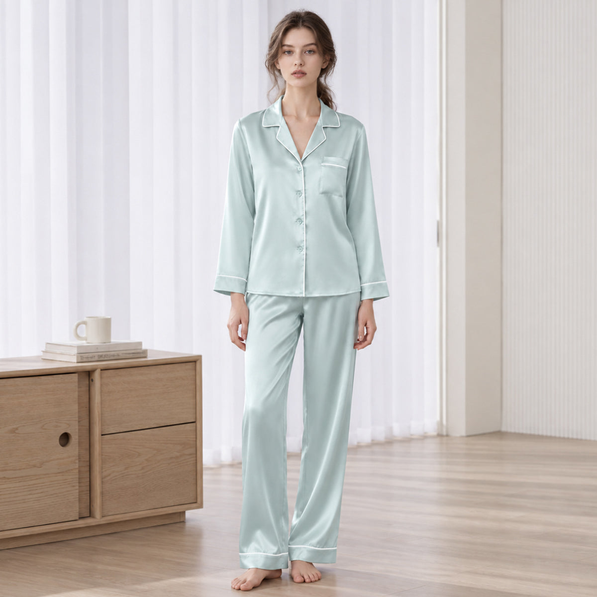 Light green silk pajama set with long-sleeve button-up top and matching long pants, trim