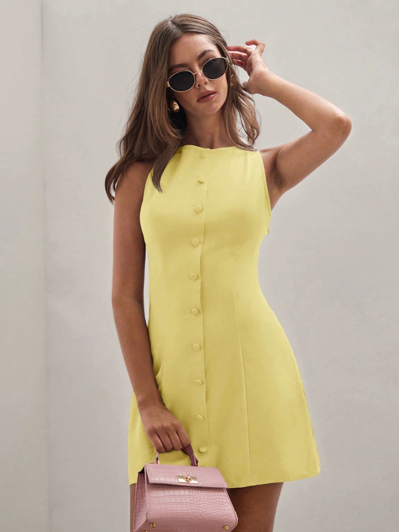 Yellow sleeveless shift dress with round neck and button-front mini hem