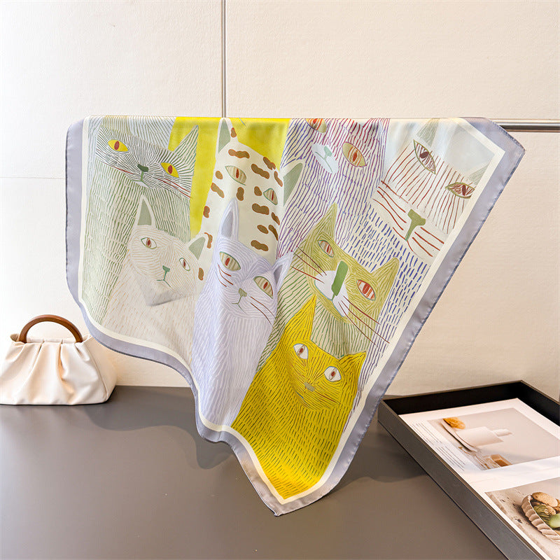 Cat-print silk-look square scarf with white base, yellow cat motif, and pale blue trim