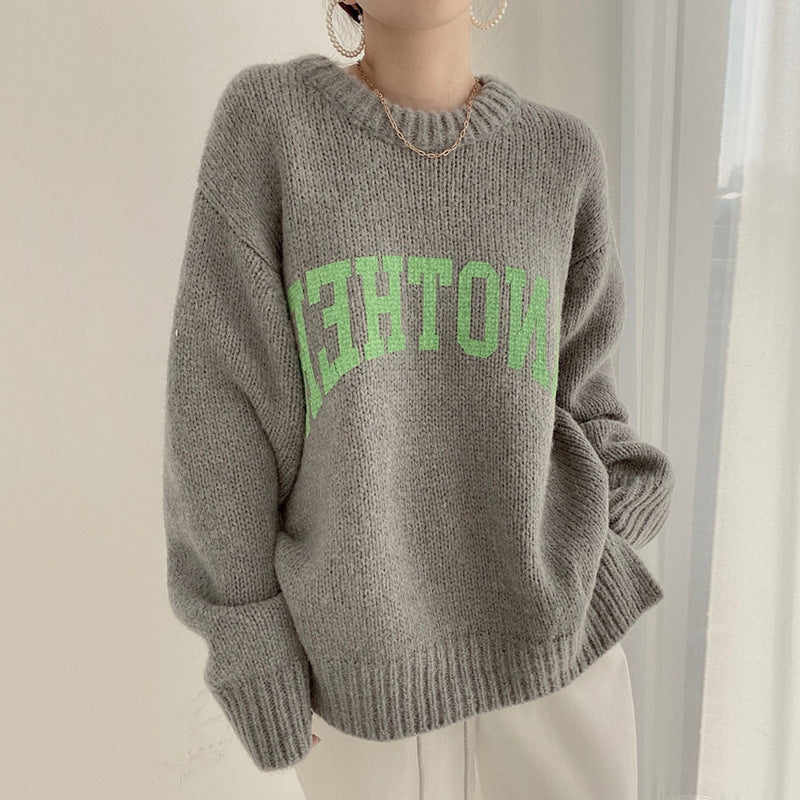 Grey chunky knit crewneck sweater with green slogan graphic